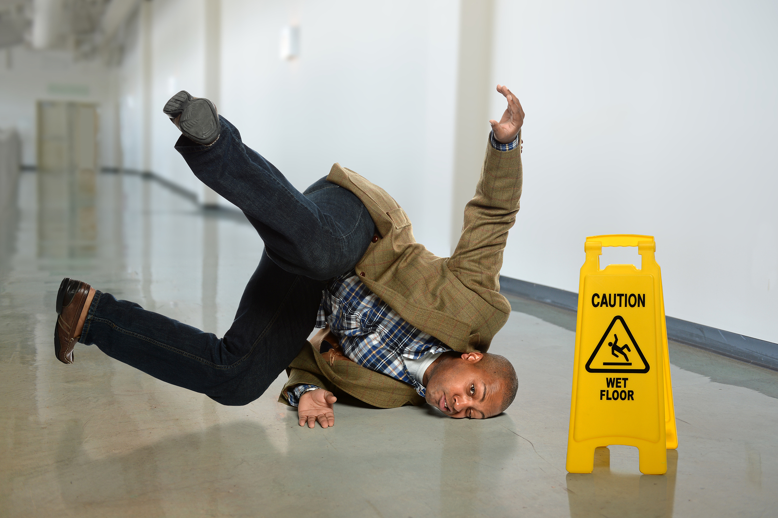 man falling on wet floor in office