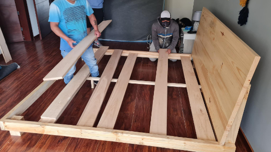 Workers assembling our custom king bed